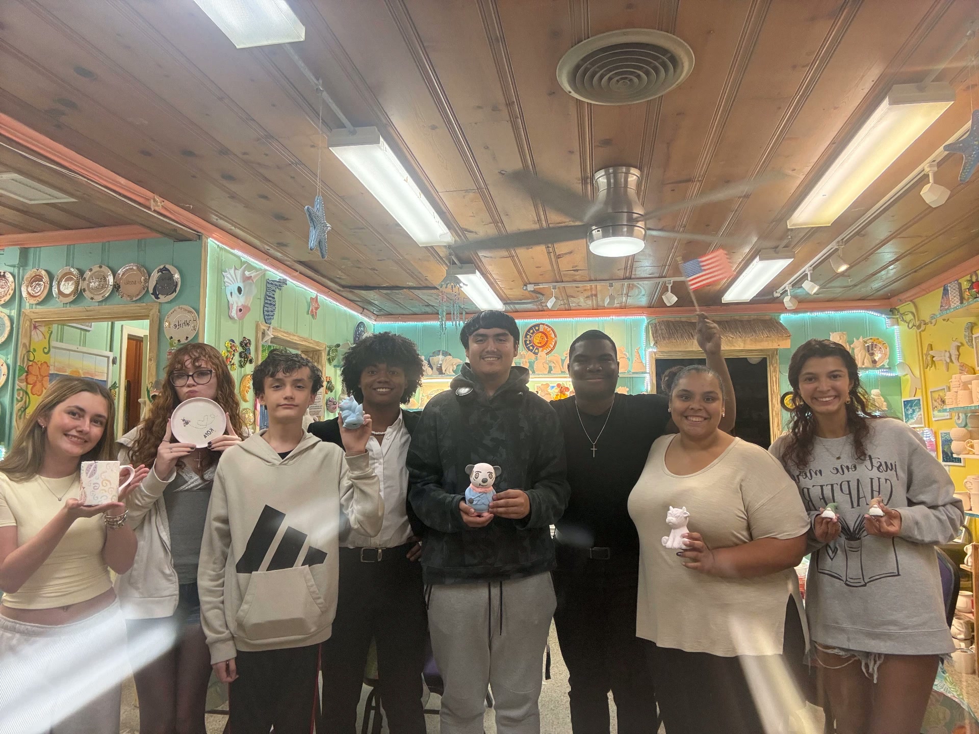 Uncommon Thursdays students holding their painted pottery at Stuart Ceramics