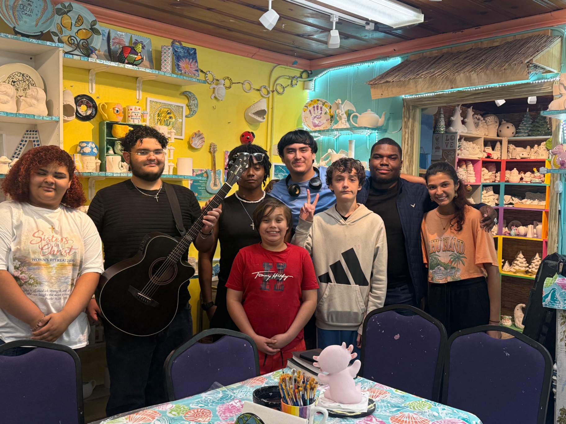 Teens gathered together with a guitar at an Uncommon Thursdays night